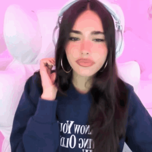 A Woman Wearing Headphones And A Blue Sweatshirt That Says Toy Wow GIF