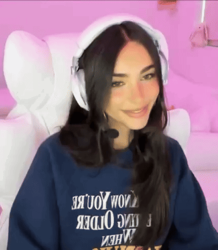 A Woman Wearing Headphones And A Blue Sweatshirt With The Word Order On It . GIF