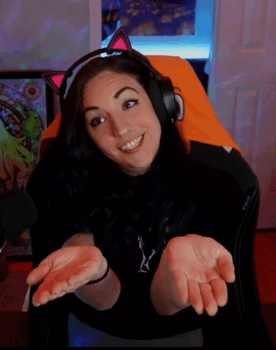 A Woman Wearing Headphones And A Cat Ear Headband Smiles GIF