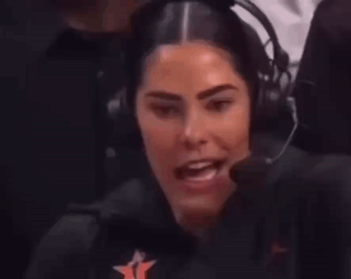 A Woman Wearing Headphones And A Microphone Is Sitting In Front Of A Microphone . GIF