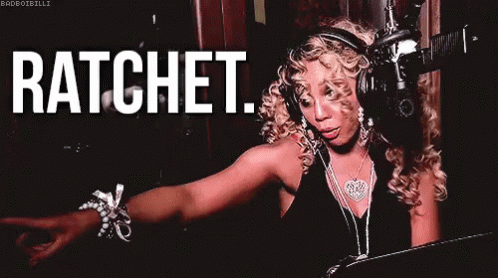 A Woman Wearing Headphones And A Necklace Is Standing In Front Of A Microphone And Says Ratchet . GIF