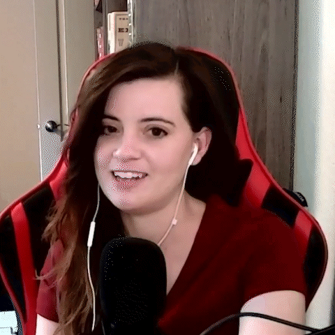 A Woman Wearing Headphones And A Red Shirt Is Sitting In A Red Chair . GIF