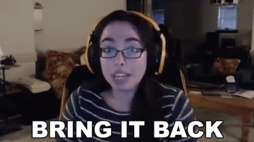 A Woman Wearing Headphones And Glasses Is Sitting In Front Of A Computer Screen . GIF