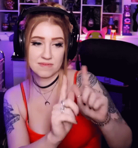 A Woman Wearing Headphones Giving A Thumbs Up Sign GIF