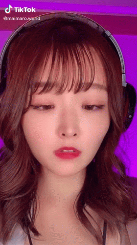 A Woman Wearing Headphones Has A Tiktok Sticker On Her Face GIF