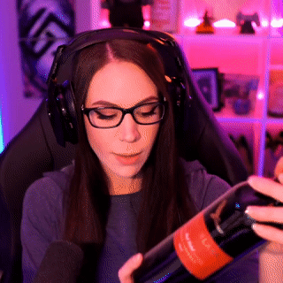 A Woman Wearing Headphones Holds A Bottle Of Wine GIF