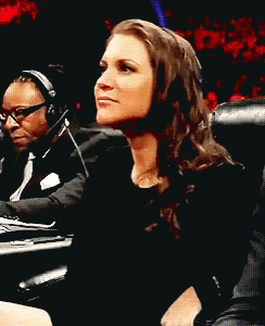 A Woman Wearing Headphones Is Laughing While Sitting Next To A Man GIF