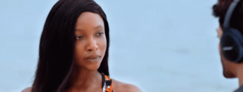 A Woman Wearing Headphones Is Looking At A Man GIF