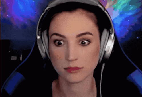 A Woman Wearing Headphones Is Making A Funny Face GIF
