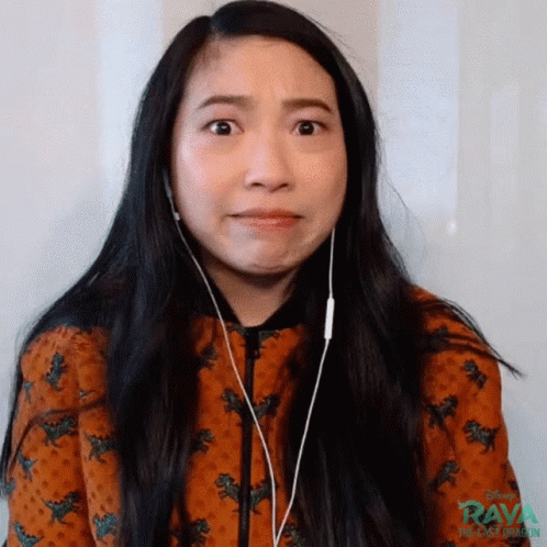 A Woman Wearing Headphones Is Making A Funny Face While Looking At The Camera . GIF