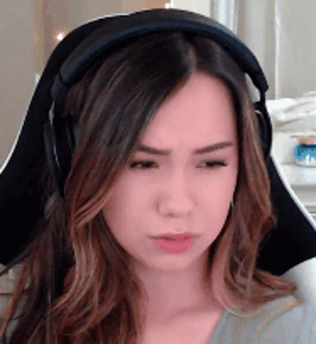 A Woman Wearing Headphones Is Sitting In A Chair And Making A Funny Face . GIF