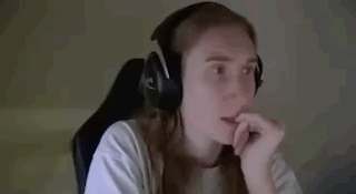a woman wearing headphones is sitting in a chair and waving her hand .