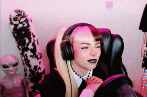 A Woman Wearing Headphones Is Sitting In A Chair . GIF