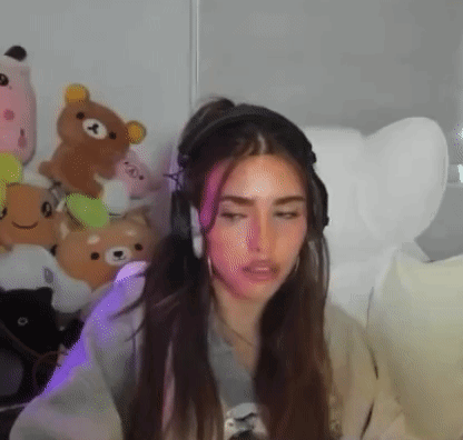 A Woman Wearing Headphones Is Sitting In A Chair In A Room With Stuffed Animals . GIF