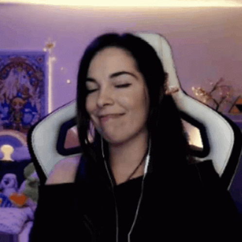 A Woman Wearing Headphones Is Sitting In A Chair With Her Eyes Closed GIF