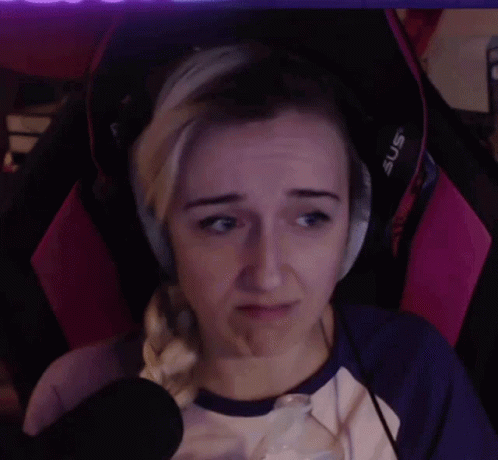 A Woman Wearing Headphones Is Sitting In A Pink Chair And Making A Sad Face . GIF