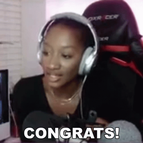 A Woman Wearing Headphones Is Sitting In Front Of A Computer And Says Congrats . GIF