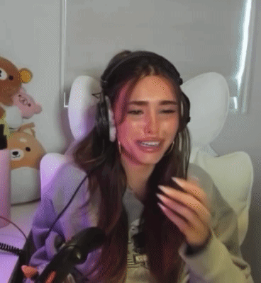 A Woman Wearing Headphones Is Sitting In Front Of A Microphone In A Chair . GIF