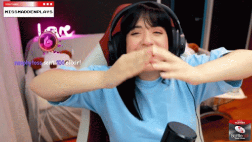 A Woman Wearing Headphones Is Sitting In Front Of A Screen That Says Missmaddenplays On It GIF