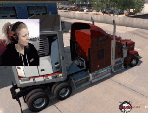 A Woman Wearing Headphones Is Sitting In Front Of A Semi Truck GIF