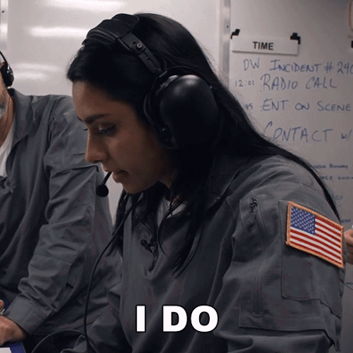 A Woman Wearing Headphones Is Sitting In Front Of A White Board That Says Time GIF