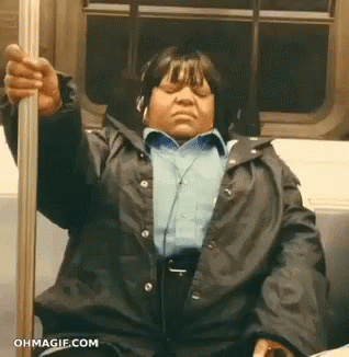 A Woman Wearing Headphones Is Sitting On A Train With Her Eyes Closed .. GIF