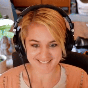 A Woman Wearing Headphones Is Smiling And Making A Funny Face GIF