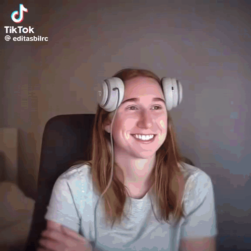 a woman wearing headphones is smiling in a tiktok