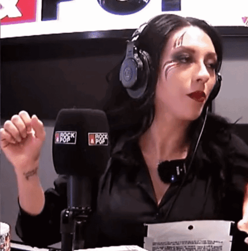 A Woman Wearing Headphones Is Talking Into A Microphone That Says Rock Pop GIF