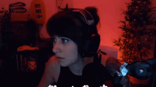 A Woman Wearing Headphones With A Sign That Says Come Over In The Background GIF