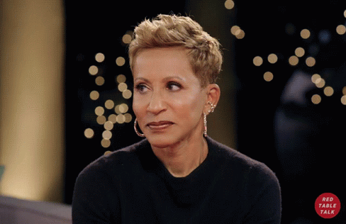 A Woman Wearing Hoop Earrings And A Black Shirt With A Red Circle That Says Red Table Talk GIF