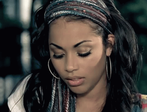 A Woman Wearing Hoop Earrings And A Headband Is Looking Down GIF