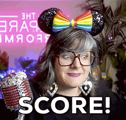 A Woman Wearing Mouse Ears And Glasses Is Holding A Microphone And Saying Score ! GIF