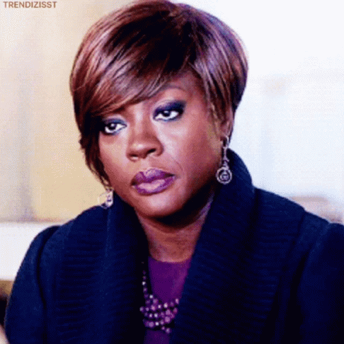 A Woman Wearing Purple Lipstick And Earrings Is Making A Face . GIF