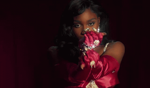 A Woman Wearing Red Gloves And A Necklace With Diamonds GIF