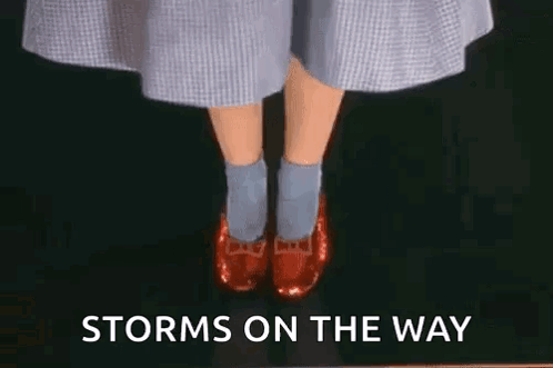 A Woman Wearing Red Shoes And Blue Socks Is Standing On A Black Surface With The Words `` Storms On The Way '' . GIF