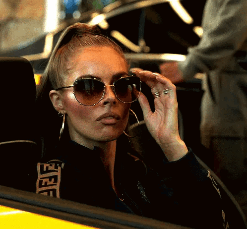 A Woman Wearing Sunglasses And A Black Jacket With A Fendi Logo On The Back GIF