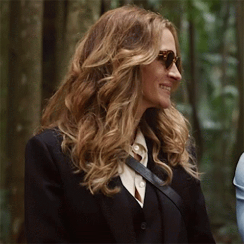 A Woman Wearing Sunglasses And A Black Suit Jacket GIF