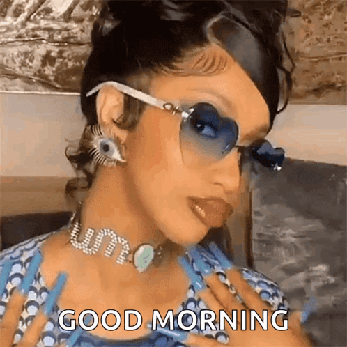 A Woman Wearing Sunglasses And A Choker Is Giving A Good Morning Message . GIF