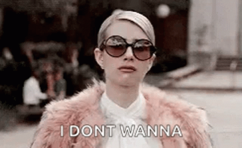 A Woman Wearing Sunglasses And A Fur Coat Is Standing On A Street . GIF