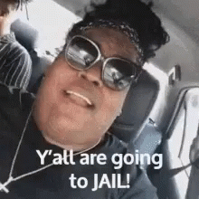 A Woman Wearing Sunglasses And A Headband Is Sitting In A Car And Smiling . GIF