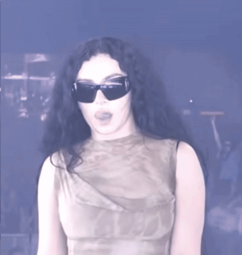 A Woman Wearing Sunglasses And A Sleeveless Top GIF