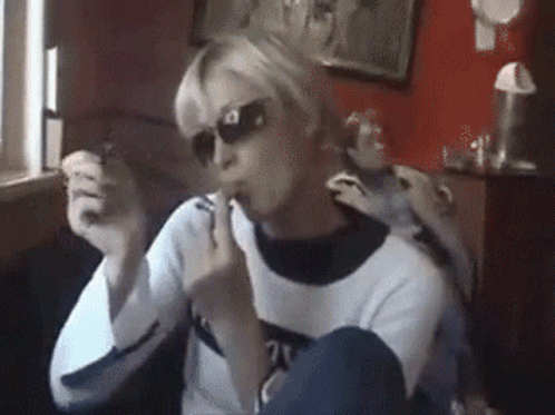 A Woman Wearing Sunglasses And A Sweater With The Number 21 On The Front GIF