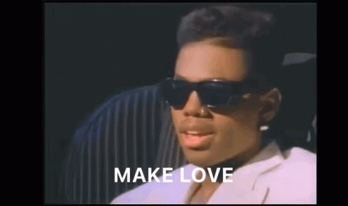A Woman Wearing Sunglasses And A White Jacket With The Words Make Love Above Her GIF