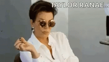 A Woman Wearing Sunglasses And A White Shirt Is Sitting In A Chair And Making A Funny Face . GIF