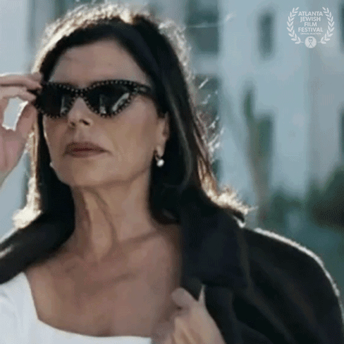 A Woman Wearing Sunglasses Has A Laurel Wreath Behind Her GIF
