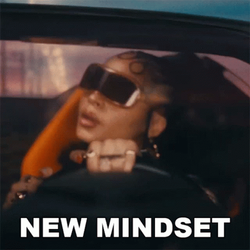 A Woman Wearing Sunglasses Is Driving A Car With The Words New Mindset Written On The Bottom GIF
