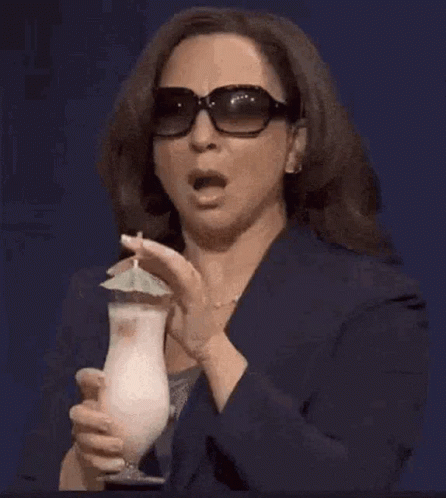 A Woman Wearing Sunglasses Is Holding A Drink With An Umbrella And The Words Oh No Behind Her GIF