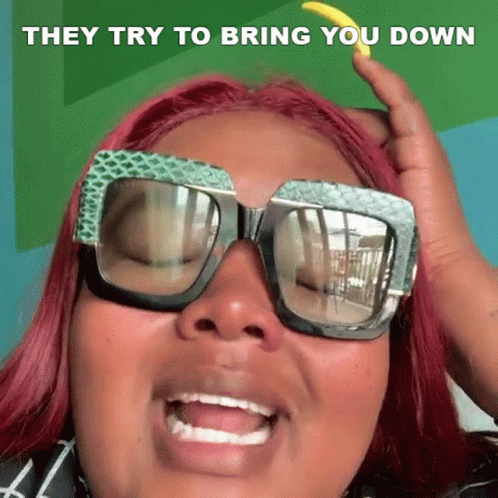 A Woman Wearing Sunglasses Is Making A Funny Face And They Try To Bring You Down GIF