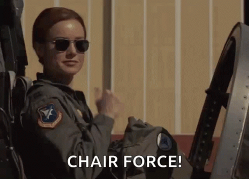 A Woman Wearing Sunglasses Is Sitting In A Chair With The Words Chair Force Below Her GIF
